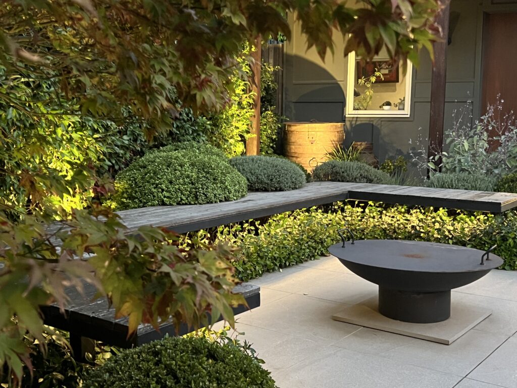 firepit with floating bench seating and soft plants